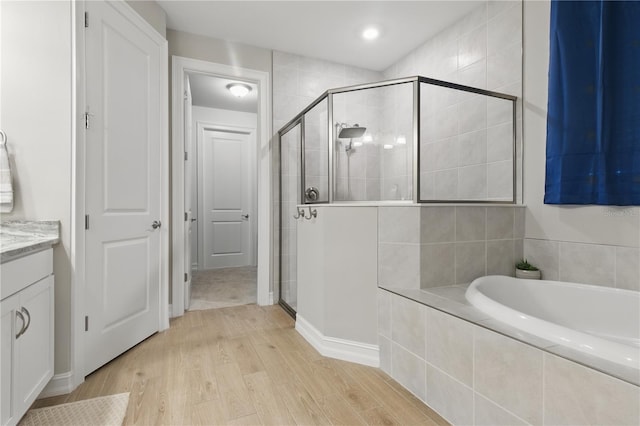 15963 Crofton Springs Way, Port Charlotte, FL 33953 - bathroom featuring a garden tub, a shower stall, wood finished floors, and vanity
