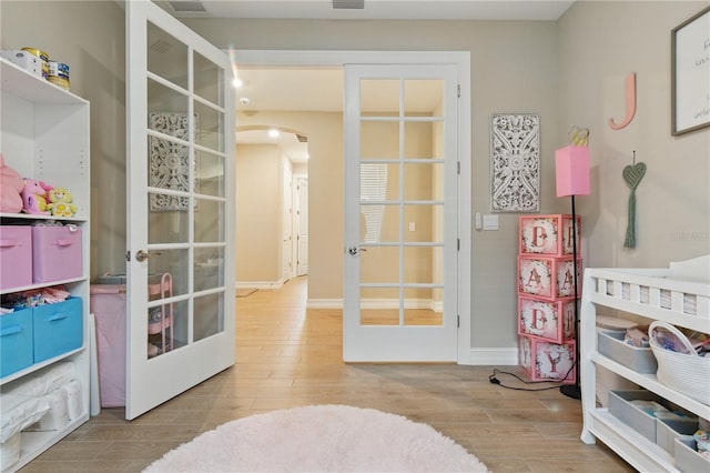 15963 Crofton Springs Way, Port Charlotte, FL 33953 - game room featuring french doors, arched walkways, and wood finished floors