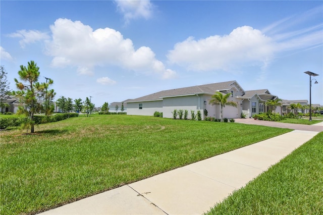 15963 Crofton Springs Way, Port Charlotte, FL 33953 - view of side of property featuring driveway, a lawn, stucco siding, a garage, and a residential view