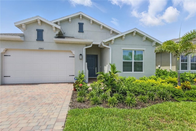 15963 Crofton Springs Way, Port Charlotte, FL 33953 - view of front of house featuring stucco siding, decorative driveway, and an attached garage