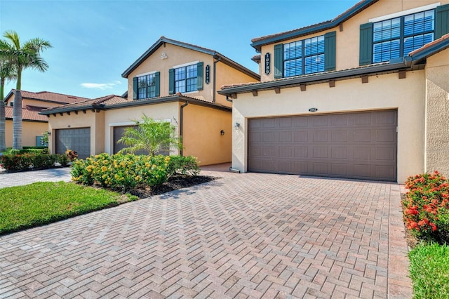 10789 Tarflower Dr Unit 202, Venice, FL 34293 - mediterranean / spanish-style house featuring stucco siding, a garage, and decorative driveway
