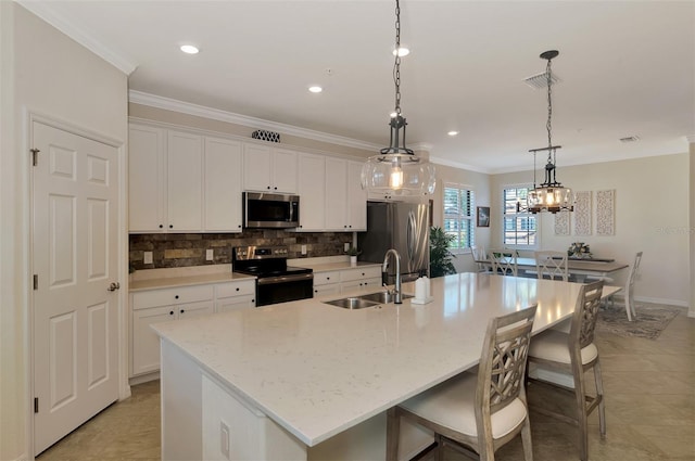 10789 Tarflower Dr Unit 202, Venice, FL 34293 - kitchen featuring stainless steel appliances, ornamental molding, an island with sink, backsplash, and white cabinetry
