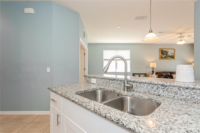 11954 Tempest Harbor Loop, Venice, FL 34292 - kitchen featuring decorative light fixtures, ceiling fan, light stone counters, white cabinets, and light tile patterned floors