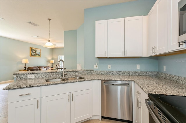 11954 Tempest Harbor Loop, Venice, FL 34292 - kitchen featuring stainless steel appliances, a peninsula, light stone counters, and white cabinetry