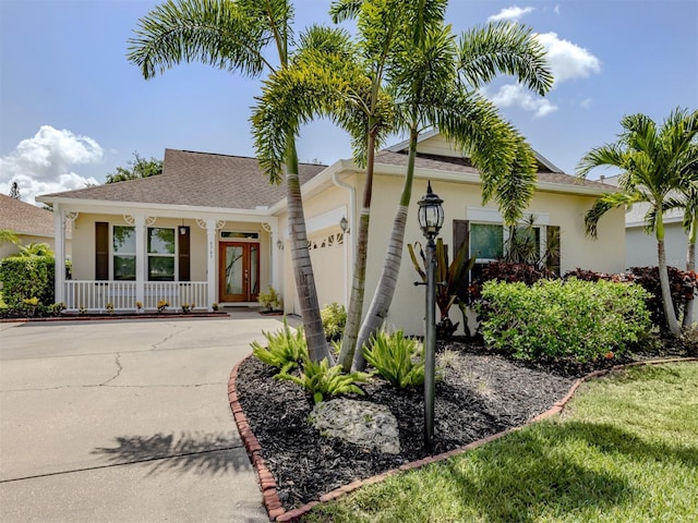 6505 Meandering Way, Lakewood Ranch, FL 34202 - view of front of house with covered porch, an attached garage, stucco siding, driveway, and roof with shingles