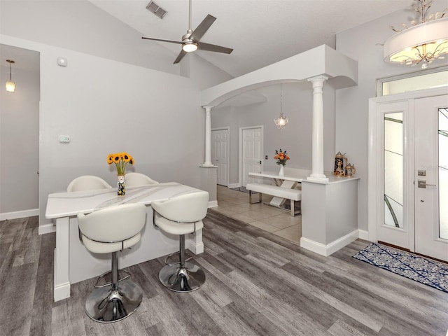 6505 Meandering Way, Lakewood Ranch, FL 34202 - dining area featuring wood finished floors, ornate columns, a ceiling fan, arched walkways, and high vaulted ceiling