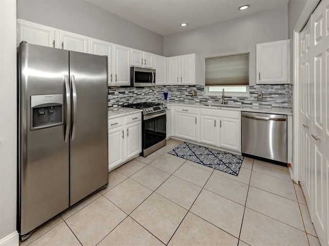 6505 Meandering Way, Lakewood Ranch, FL 34202 - kitchen featuring appliances with stainless steel finishes, light countertops, decorative backsplash, white cabinets, and light tile patterned flooring