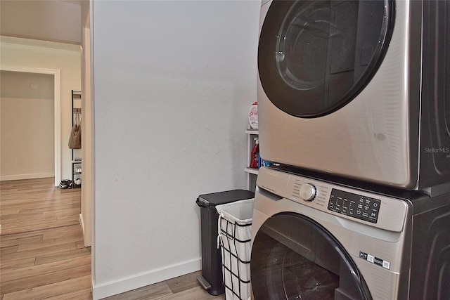 3340 Webber St, Sarasota, FL 34239 - laundry area featuring stacked washer / dryer, light wood-style flooring, and baseboards