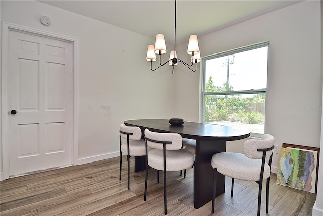 3340 Webber St, Sarasota, FL 34239 - dining room featuring light wood finished floors, a chandelier, and baseboards