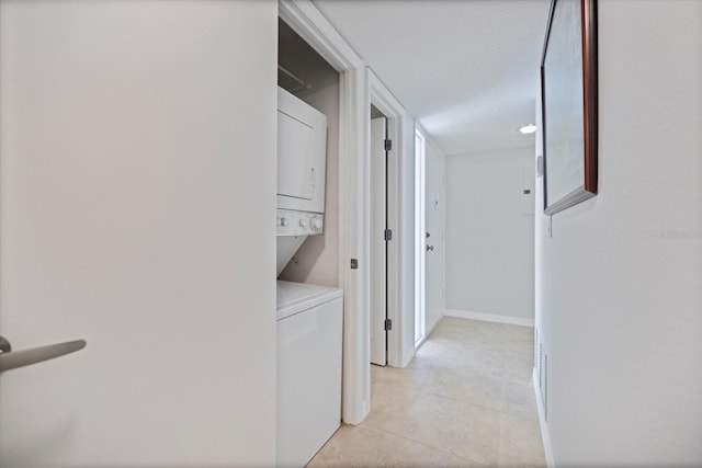 751 Capri Isles Blvd Unit 108, Venice, FL 34292 - laundry room with stacked washing machine and dryer and light tile patterned floors