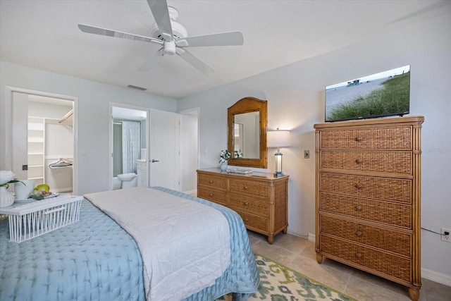 751 Capri Isles Blvd Unit 108, Venice, FL 34292 - bedroom with baseboards, ceiling fan, light tile patterned floors, ensuite bathroom, and a walk in closet