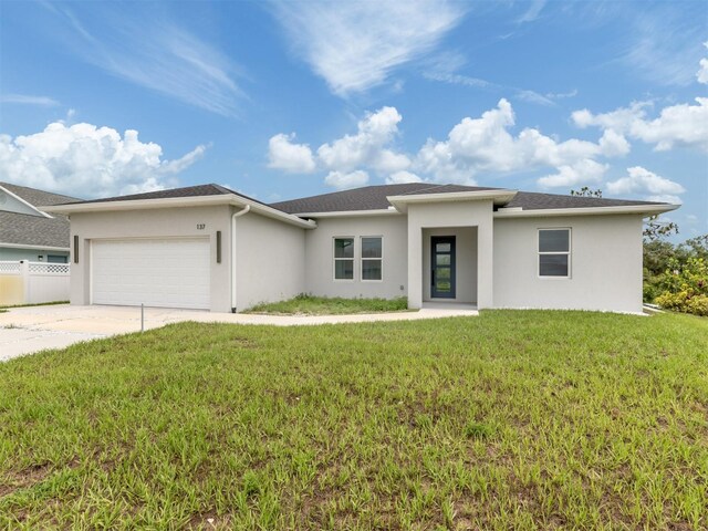 137 Mariner Ln, Rotonda West, FL 33947 - prairie-style home with an attached garage, stucco siding, and driveway