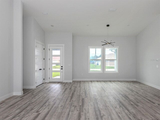 137 Mariner Ln, Rotonda West, FL 33947 - empty room with wood finished floors, baseboards, and a chandelier