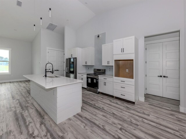 137 Mariner Ln, Rotonda West, FL 33947 - kitchen featuring stainless steel appliances, a sink, high vaulted ceiling, white cabinets, and baseboards