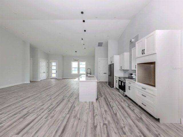 137 Mariner Ln, Rotonda West, FL 33947 - kitchen featuring stainless steel electric stove, high vaulted ceiling, open floor plan, white cabinetry, and fridge