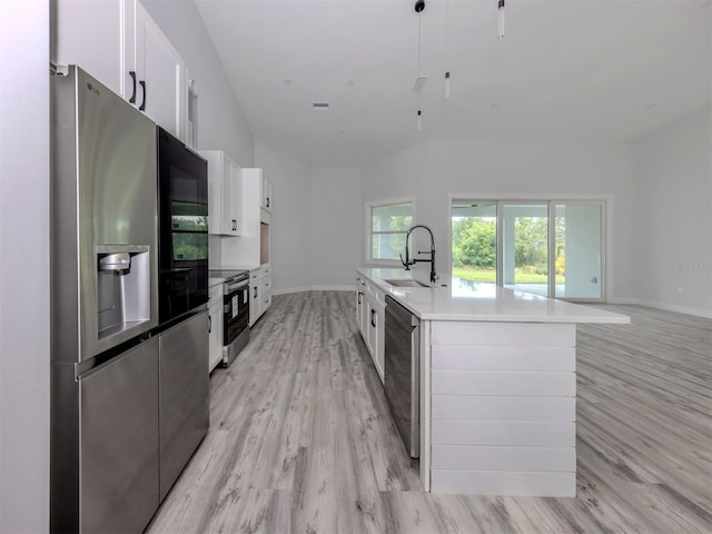 137 Mariner Ln, Rotonda West, FL 33947 - kitchen featuring stainless steel appliances, a sink, white cabinets, light wood-style floors, and light countertops