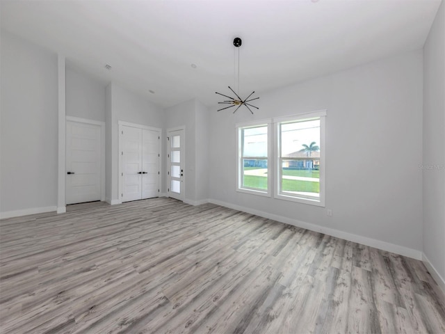 137 Mariner Ln, Rotonda West, FL 33947 - unfurnished living room with light wood-style flooring, baseboards, and vaulted ceiling