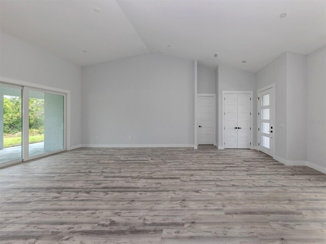 137 Mariner Ln, Rotonda West, FL 33947 - unfurnished living room featuring vaulted ceiling, wood finished floors, and baseboards