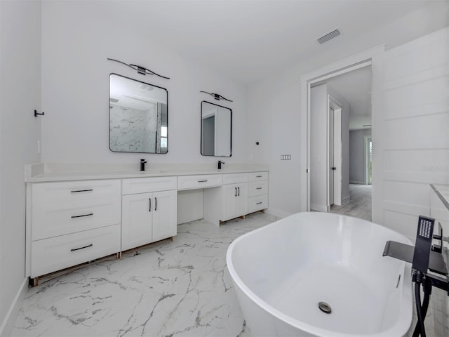 137 Mariner Ln, Rotonda West, FL 33947 - bathroom with marble finish flooring, double vanity, a freestanding bath, and baseboards