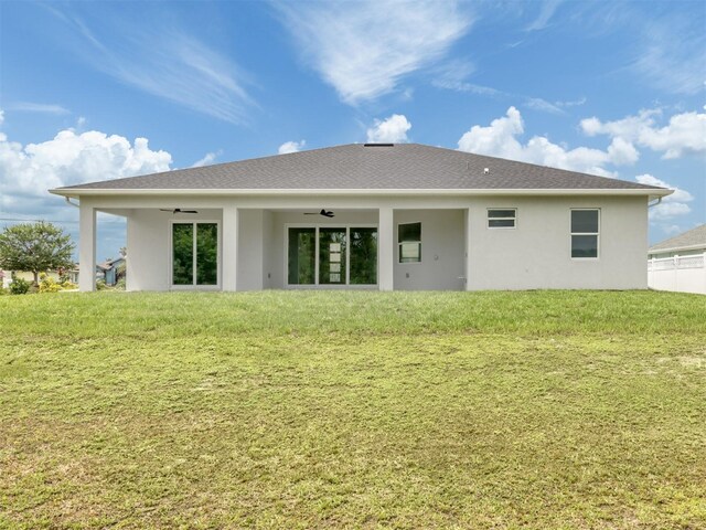 137 Mariner Ln, Rotonda West, FL 33947 - back of property featuring ceiling fan, a yard, and stucco siding