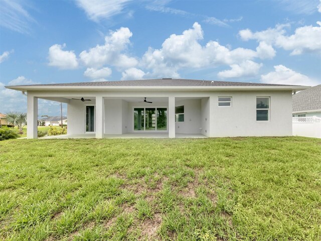 137 Mariner Ln, Rotonda West, FL 33947 - back of property featuring a ceiling fan, stucco siding, a patio, and a yard
