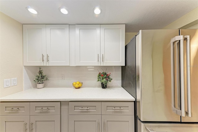 2718 Orchid Oaks Dr Unit C-202, Sarasota, FL 34239 - kitchen featuring freestanding refrigerator, decorative backsplash, white cabinets, and recessed lighting