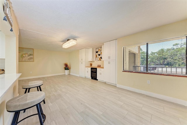 2718 Orchid Oaks Dr Unit C-202, Sarasota, FL 34239 - unfurnished living room with wine cooler and baseboards