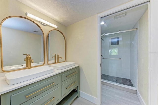 2718 Orchid Oaks Dr Unit C-202, Sarasota, FL 34239 - full bathroom with double vanity, a shower stall, a textured ceiling, and tile patterned floors