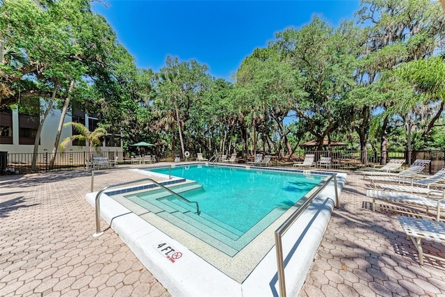 2718 Orchid Oaks Dr Unit C-202, Sarasota, FL 34239 - community pool featuring a patio area and view of scattered trees