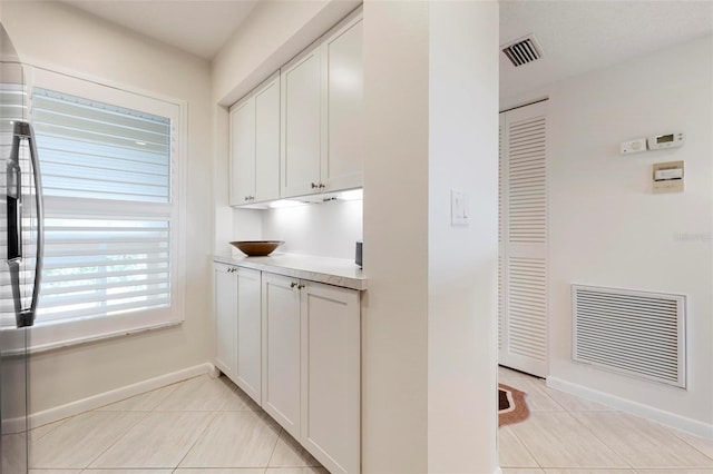 849 Wexford Blvd Unit 849, Venice, FL 34293 - kitchen with light tile patterned floors, white cabinetry, light countertops, and freestanding refrigerator