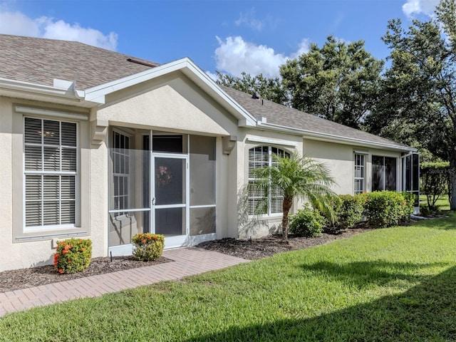 29704 Niagara Ct, Englewood, FL 34223 - view of side of home featuring stucco siding, a yard, a sunroom, and a shingled roof