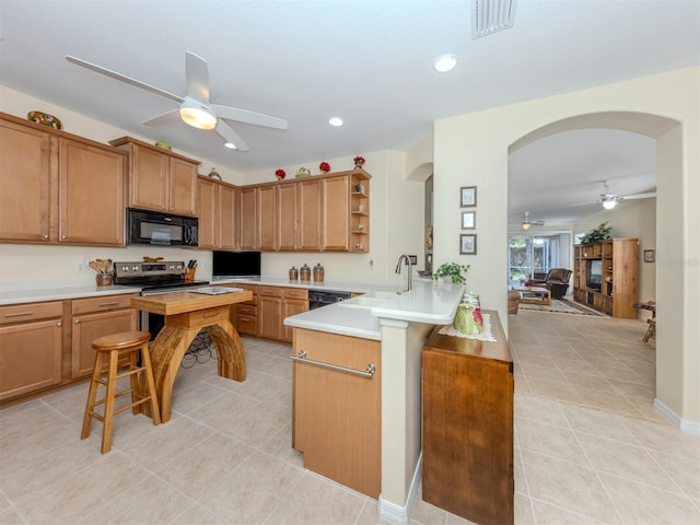 29704 Niagara Ct, Englewood, FL 34223 - kitchen with black appliances, ceiling fan, arched walkways, light tile patterned floors, and open shelves