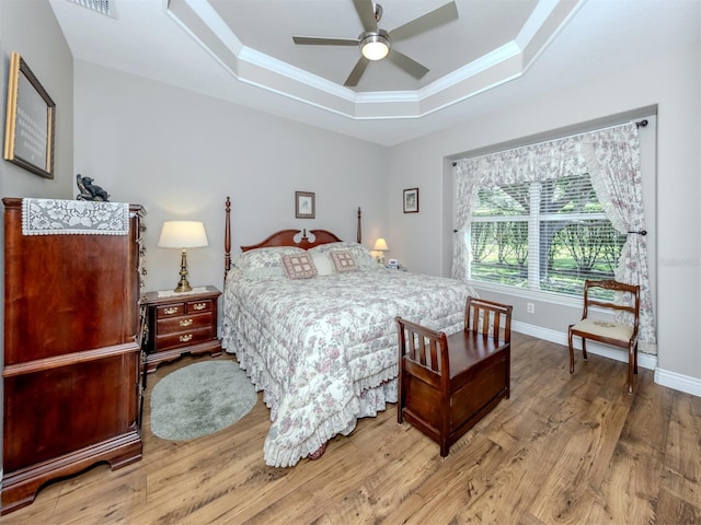 29704 Niagara Ct, Englewood, FL 34223 - bedroom featuring a raised ceiling, wood finished floors, crown molding, and a ceiling fan