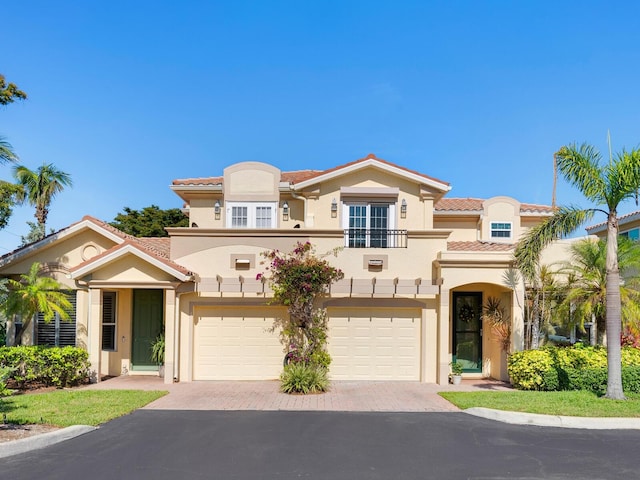 1164 Beachcomber Ct Unit 19, Osprey, FL 34229 - mediterranean / spanish-style home featuring a balcony, stucco siding, driveway, an attached garage, and a tiled roof