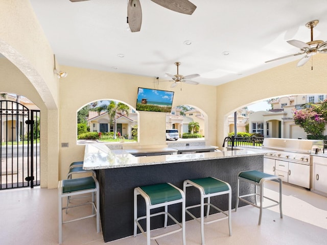 1164 Beachcomber Ct Unit 19, Osprey, FL 34229 - kitchen featuring ceiling fan, white cabinetry, a breakfast bar, and light stone countertops