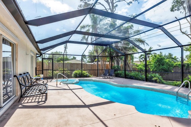 2445 Apache St, Sarasota, FL 34231 - view of swimming pool featuring a patio, a fenced backyard, a pool with connected hot tub, and a lanai