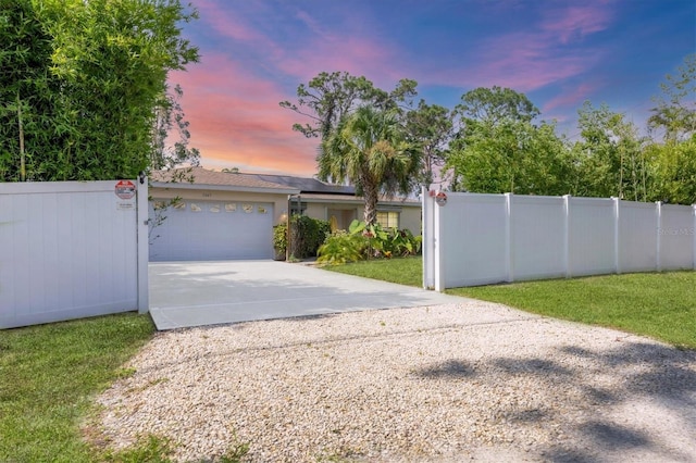 2445 Apache St, Sarasota, FL 34231 - view of front of house featuring concrete driveway, an attached garage, and solar panels