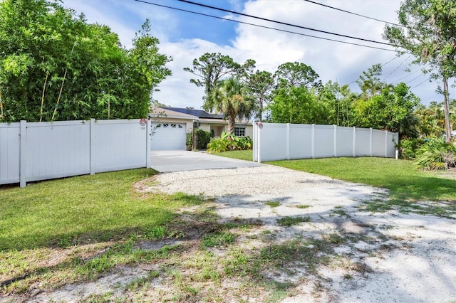 2445 Apache St, Sarasota, FL 34231 - view of yard featuring concrete driveway and a garage