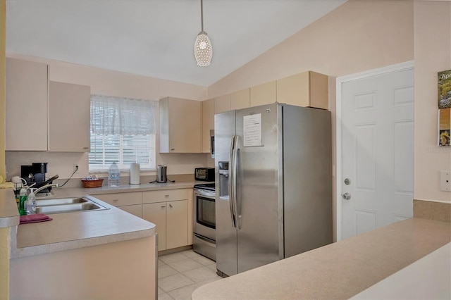 2445 Apache St, Sarasota, FL 34231 - kitchen with appliances with stainless steel finishes, lofted ceiling, cream cabinets, light countertops, and hanging light fixtures