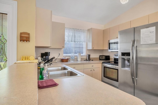 2445 Apache St, Sarasota, FL 34231 - kitchen featuring stainless steel appliances, light countertops, plenty of natural light, cream cabinets, and vaulted ceiling