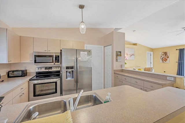 2445 Apache St, Sarasota, FL 34231 - kitchen featuring appliances with stainless steel finishes, lofted ceiling, light countertops, cream cabinetry, and pendant lighting