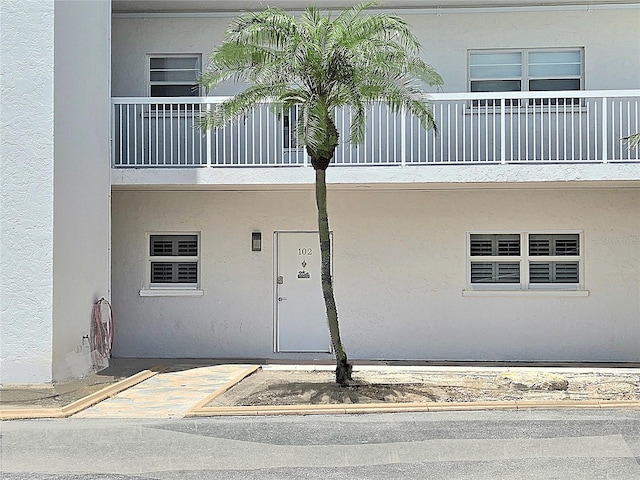 333 The Esplanade N Unit 102, Venice, FL 34285 - view of exterior entry with a balcony and stucco siding