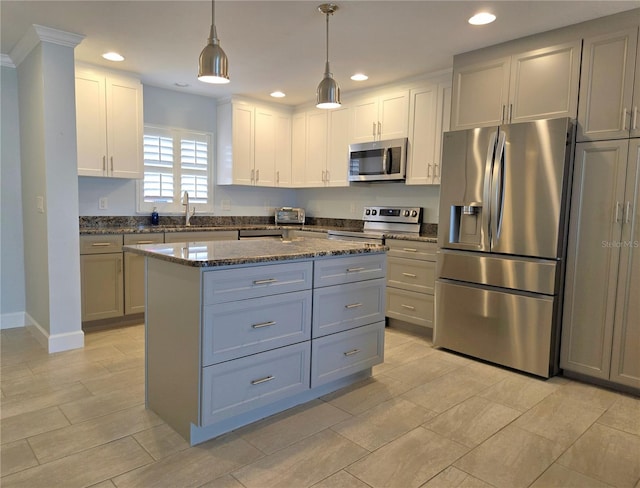 333 The Esplanade N Unit 102, Venice, FL 34285 - kitchen with stainless steel appliances, recessed lighting, dark stone countertops, a kitchen island, and white cabinetry