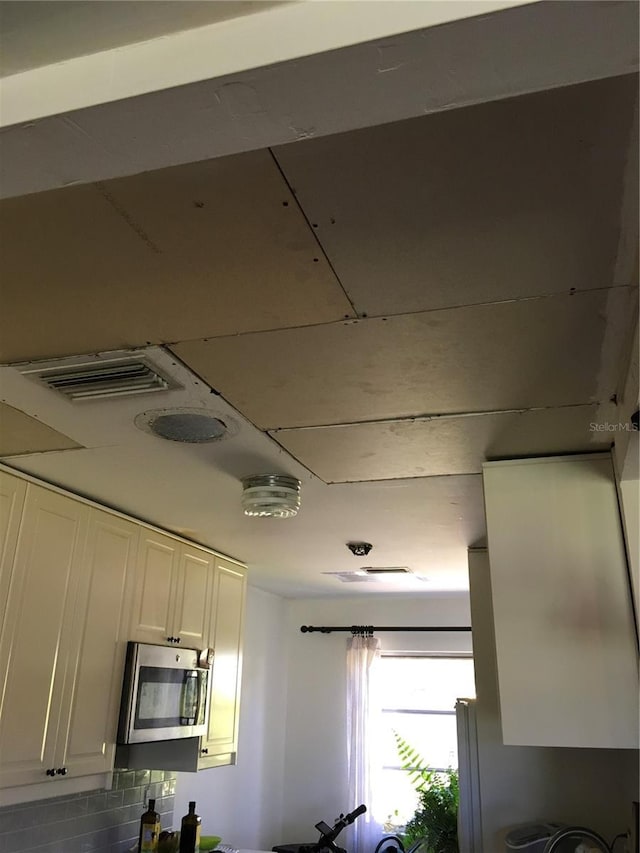 3661 Sterling Rd, Venice, FL 34293 - kitchen with stainless steel microwave and white cabinetry