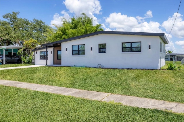 6821 Marius Rd, North Port, FL 34287 - view of front facade featuring stucco siding and a front lawn