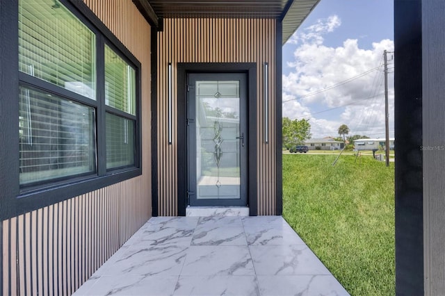 6821 Marius Rd, North Port, FL 34287 - doorway to property featuring a lawn
