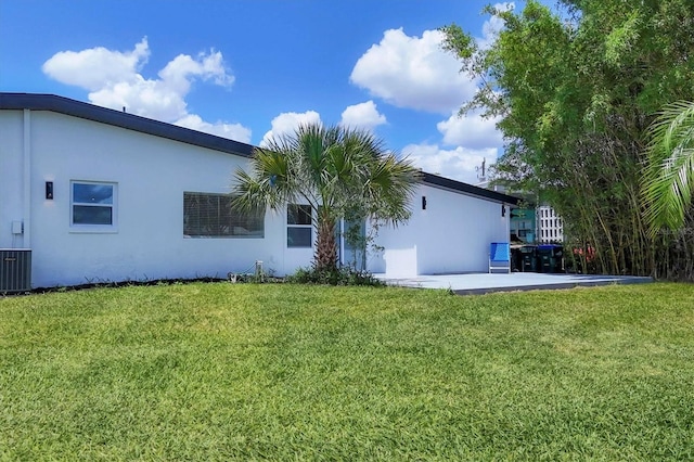 6821 Marius Rd, North Port, FL 34287 - rear view of property featuring a lawn, stucco siding, and a patio area