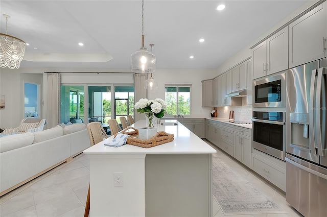 17525 Jadestone Ct, Venice, FL 34293 - kitchen featuring appliances with stainless steel finishes, gray cabinets, open floor plan, recessed lighting, and light countertops
