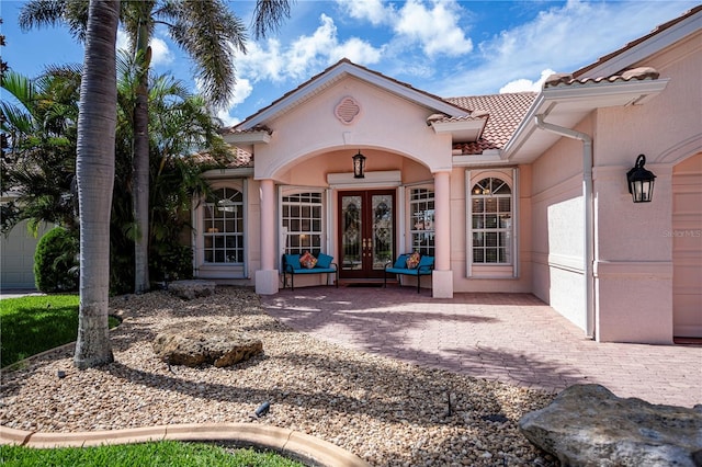 4308 Via Del Santi, Venice, FL 34293 - doorway to property featuring french doors, a tile roof, and stucco siding