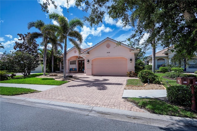 4308 Via Del Santi, Venice, FL 34293 - mediterranean / spanish home with stucco siding, a garage, and decorative driveway